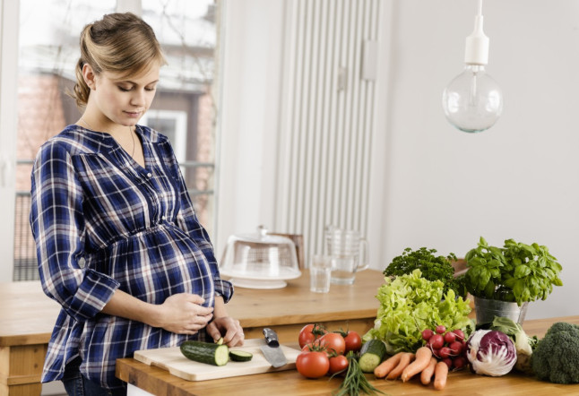 Pregnant woman chopping vegetables